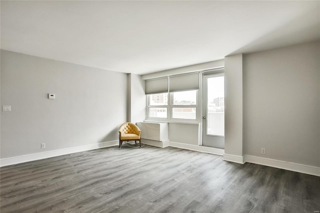 spare room with dark wood-type flooring and baseboards