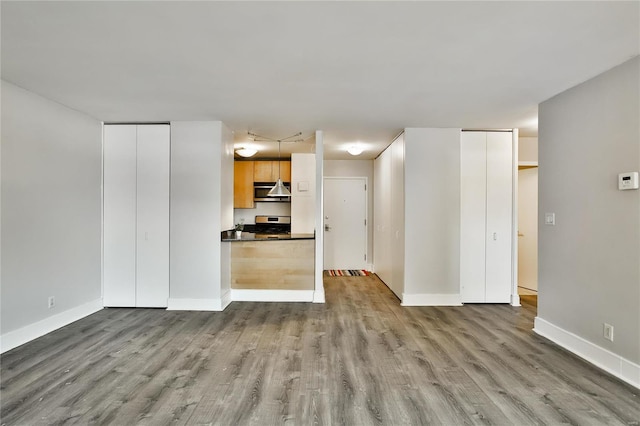 unfurnished living room with wood finished floors and baseboards