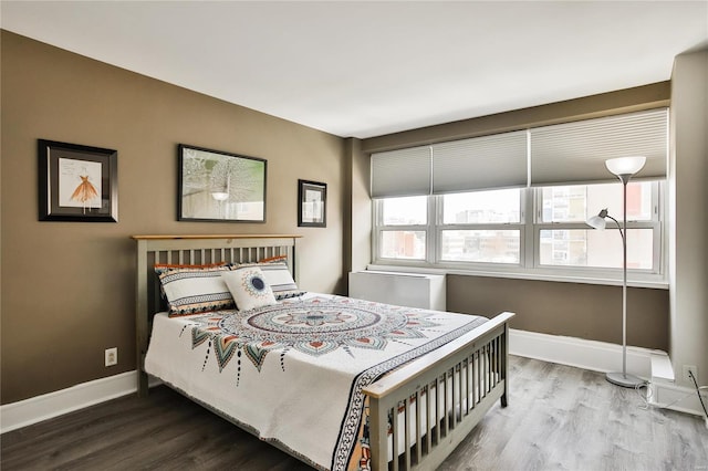 bedroom with wood finished floors and baseboards