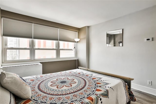 bedroom with wood finished floors and baseboards