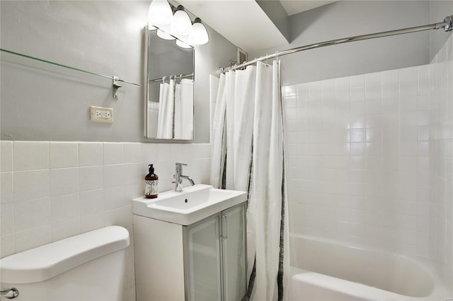 bathroom with toilet, shower / bath combo, tile walls, and vanity