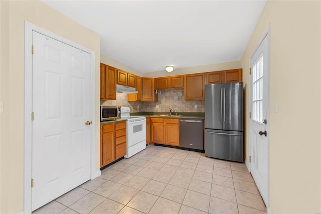 1443 Alberta Dr, Saint Charles, MO 63303 - kitchen with appliances with stainless steel finishes, under cabinet range hood, backsplash, light tile patterned floors, and a sink