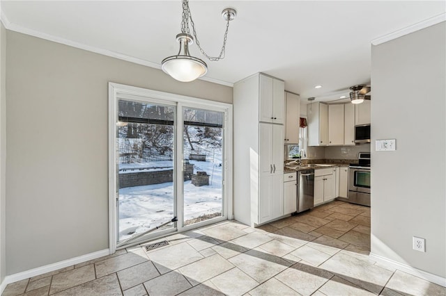 kitchen featuring stainless steel appliances, baseboards, stone tile flooring, ornamental molding, and white cabinetry