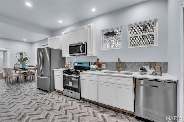 6522 Crest Ave, Saint Louis, MO 63130 - kitchen featuring stainless steel appliances, a sink, white cabinetry, light countertops, and recessed lighting