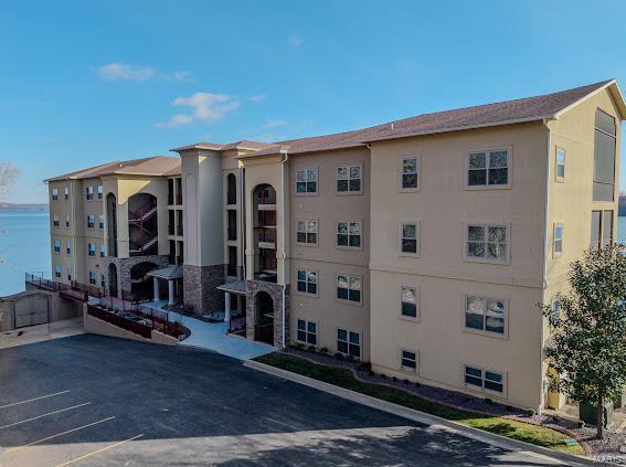 view of property featuring uncovered parking and a water view