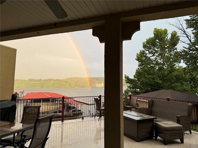 view of patio featuring a water view and a balcony