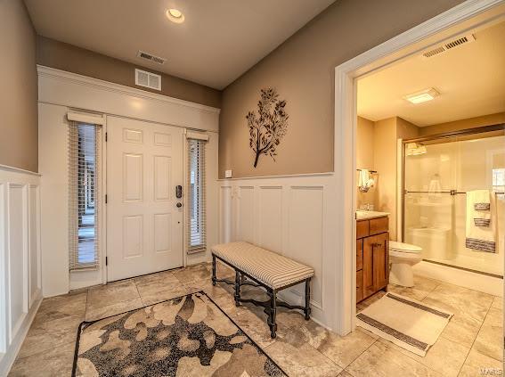 foyer featuring wainscoting and a decorative wall