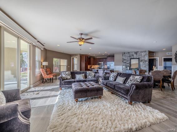 living room with wood finished floors, ceiling fan, and recessed lighting