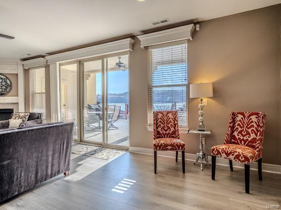 sitting room with healthy amount of natural light, a fireplace, and light wood-type flooring
