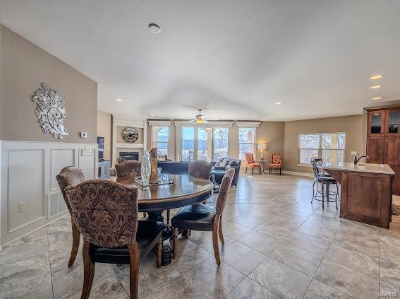 dining space featuring a ceiling fan, a fireplace, and recessed lighting