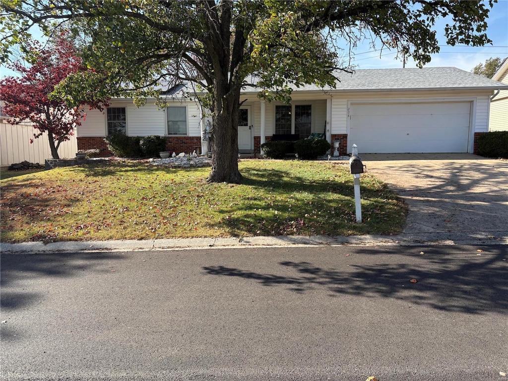 ranch-style house with brick siding, driveway, an attached garage, and a front lawn
