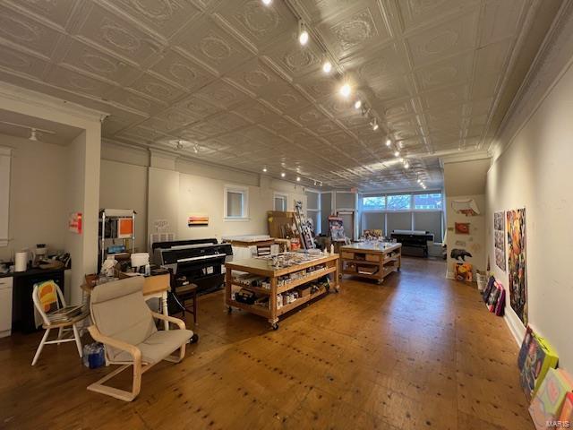 living area featuring hardwood / wood-style flooring, an ornate ceiling, and ornamental molding
