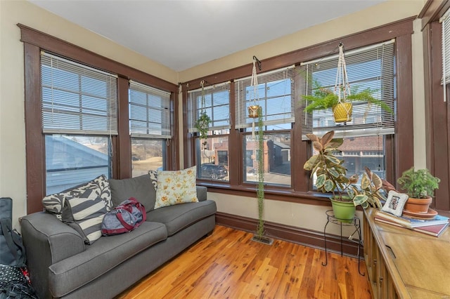 living area with plenty of natural light, light wood finished floors, and baseboards