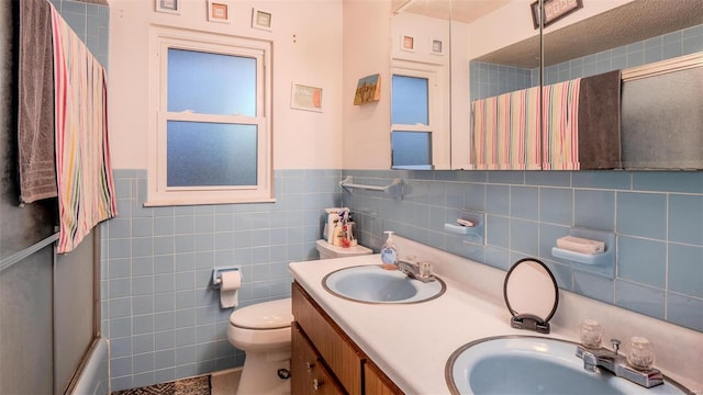 989 Clay St, Saint Clair, MO 63077 - full bathroom featuring toilet, double vanity, a wainscoted wall, tile walls, and shower / bath combination