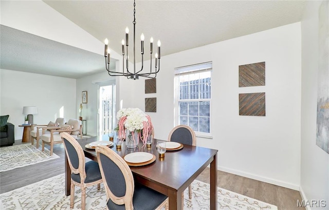 dining room featuring a chandelier, wood finished floors, and baseboards