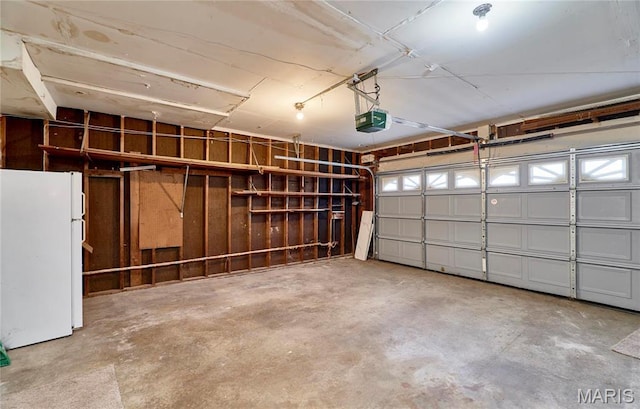 garage with freestanding refrigerator and a garage door opener