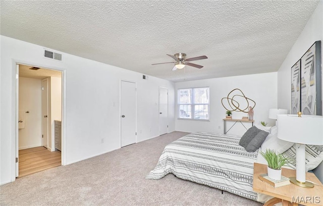 bedroom featuring carpet floors, ceiling fan, and a textured ceiling