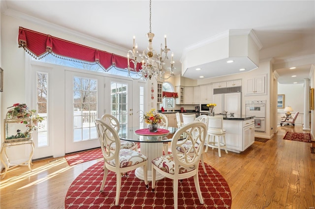 dining area with crown molding, light wood-style flooring, healthy amount of natural light, a chandelier, and recessed lighting