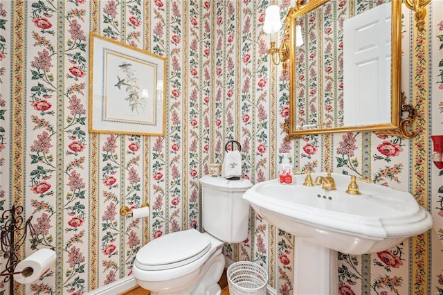 bathroom with toilet and wallpapered walls