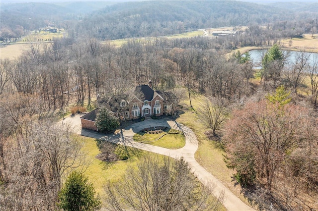 view from above of property featuring a nearby body of water and a forest