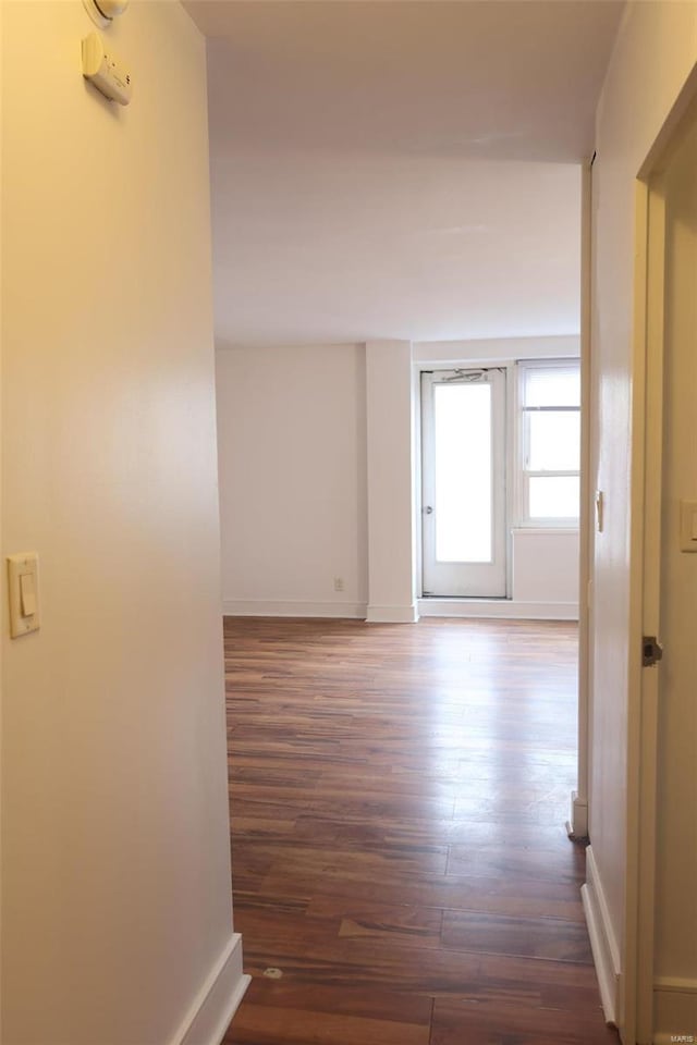 hall featuring wood finished floors and baseboards