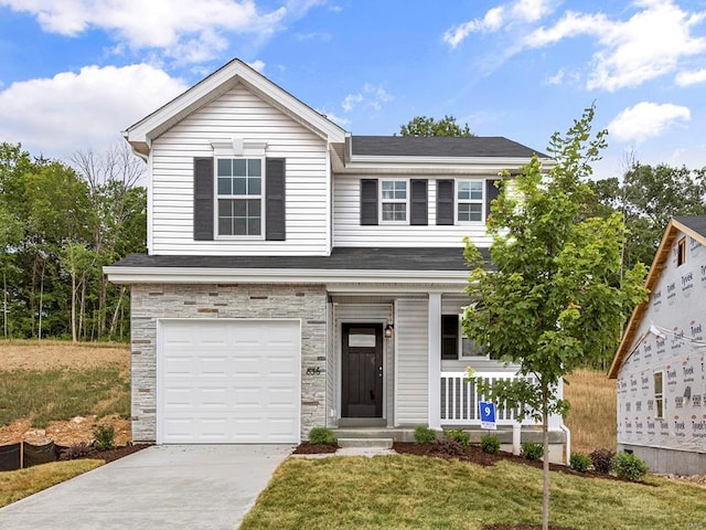 1072 Vardon Meadows Dr, Union, MO 63084 - view of front of property featuring a garage, a porch, stone siding, concrete driveway, and a front lawn