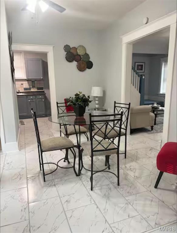 3511 Oakdale Ave, Saint Louis, MO 63121 - dining space with light marble finish floors, ceiling fan, and stairs