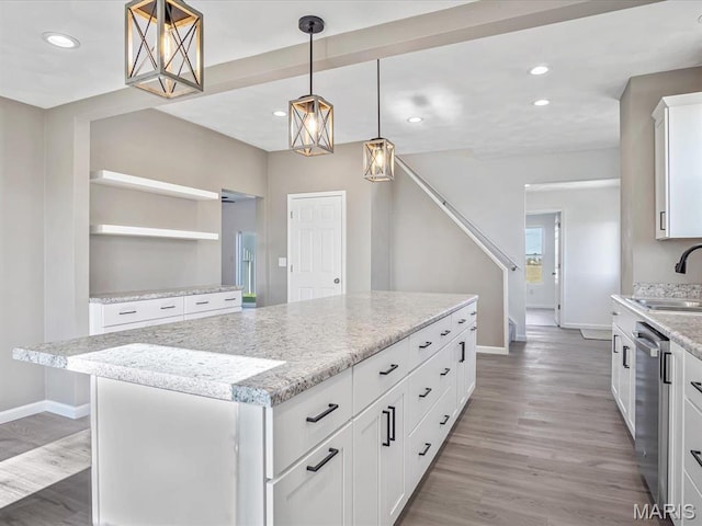 kitchen with baseboards, dishwasher, recessed lighting, light wood-style floors, and a center island