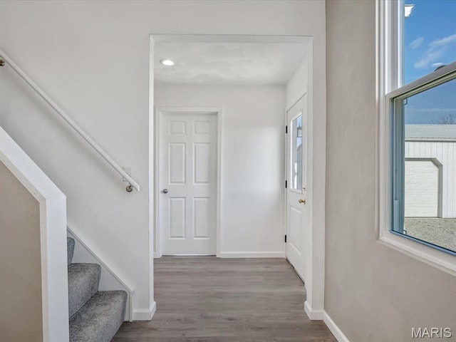 foyer entrance featuring baseboards, healthy amount of natural light, wood finished floors, stairs, and recessed lighting