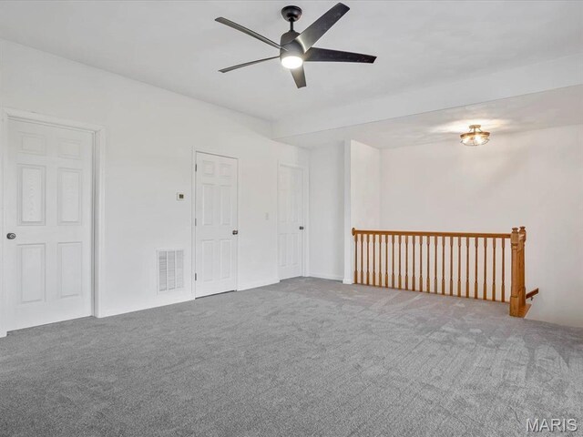 carpeted spare room featuring a ceiling fan
