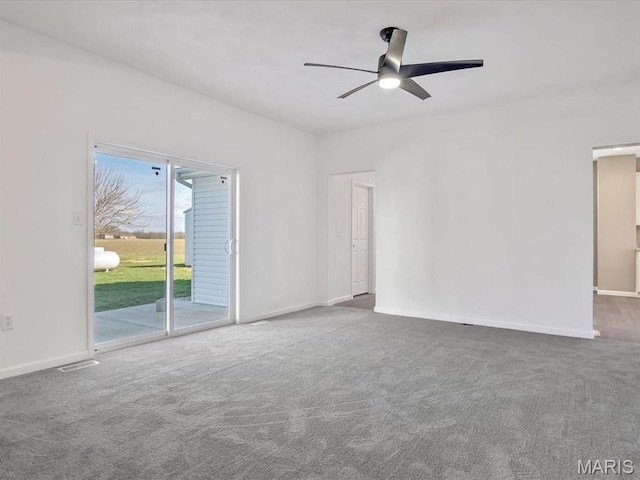 carpeted spare room featuring a ceiling fan and baseboards