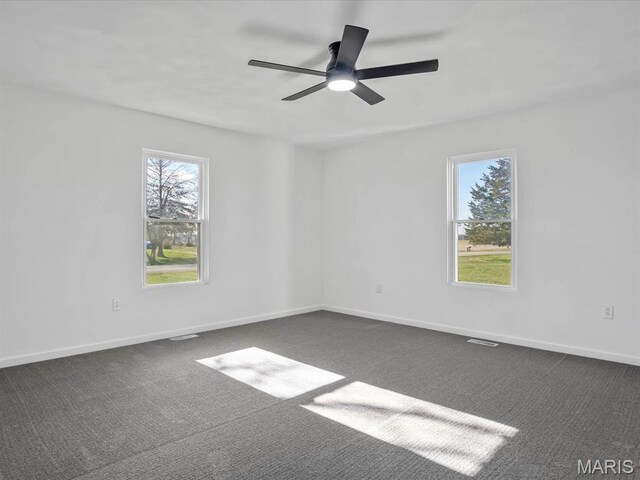 empty room with carpet flooring, ceiling fan, and baseboards