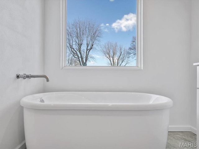 full bathroom featuring baseboards and a soaking tub