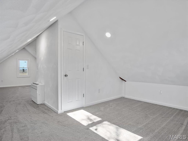 additional living space featuring vaulted ceiling, carpet flooring, baseboards, and recessed lighting