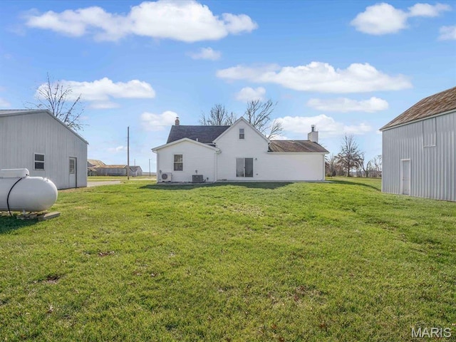 back of house with a yard and central air condition unit