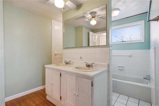 219 Cypress St, Park Hills, MO 63601 - bathroom featuring a ceiling fan, double vanity, a tub to relax in, backsplash, and tile walls