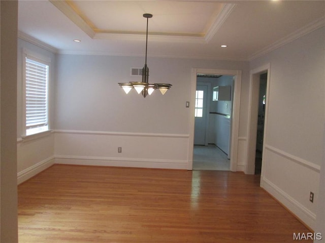7939 Delmar Blvd Unit 1W, Saint Louis, MO 63130 - unfurnished dining area featuring crown molding, plenty of natural light, light wood-type flooring, a chandelier, and a raised ceiling