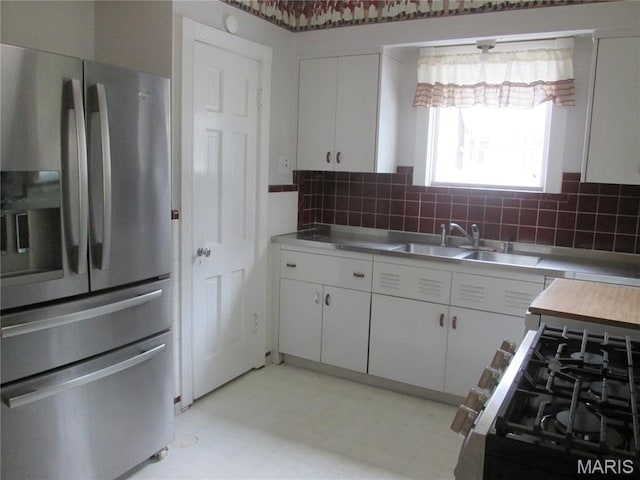 7939 Delmar Blvd Unit 1W, Saint Louis, MO 63130 - kitchen with stainless steel fridge with ice dispenser, a sink, white cabinetry, and light countertops