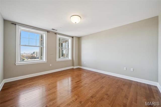empty room featuring baseboards and wood finished floors