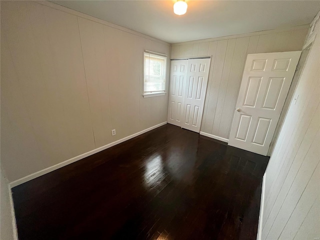 1117 Redman Blvd, Saint Louis, MO 63138 - unfurnished bedroom with dark wood finished floors, a closet, and baseboards