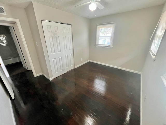 1117 Redman Blvd, Saint Louis, MO 63138 - unfurnished bedroom with dark wood finished floors, a closet, baseboards, a textured ceiling, and ceiling fan