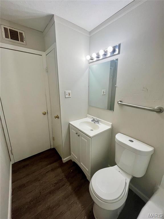 1117 Redman Blvd, Saint Louis, MO 63138 - bathroom with wood finished floors, toilet, vanity, and ornamental molding