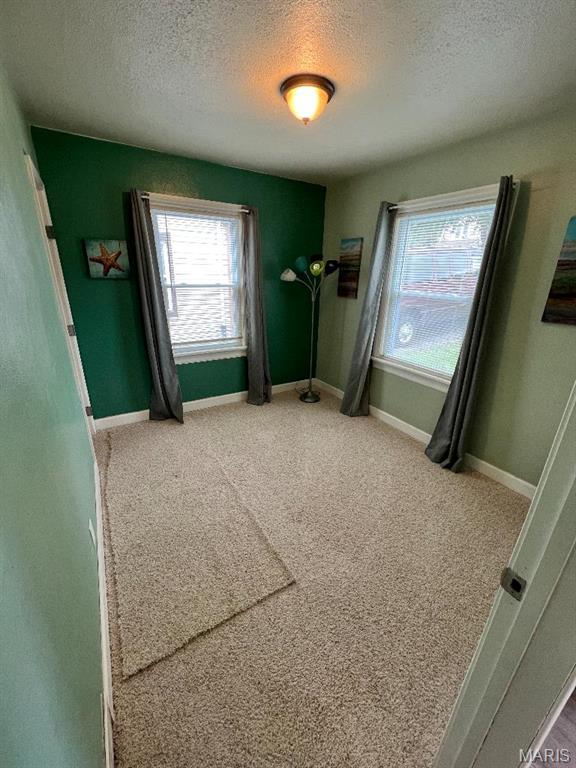 6746 Vernon Ave, University City, MO 63130 - carpeted bedroom featuring a textured ceiling, multiple windows, and baseboards