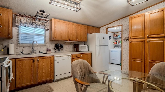 26380 Pebble Creek Dr, Warrenton, MO 63383 - kitchen featuring white appliances, washer / dryer, lofted ceiling, wallpapered walls, and a sink