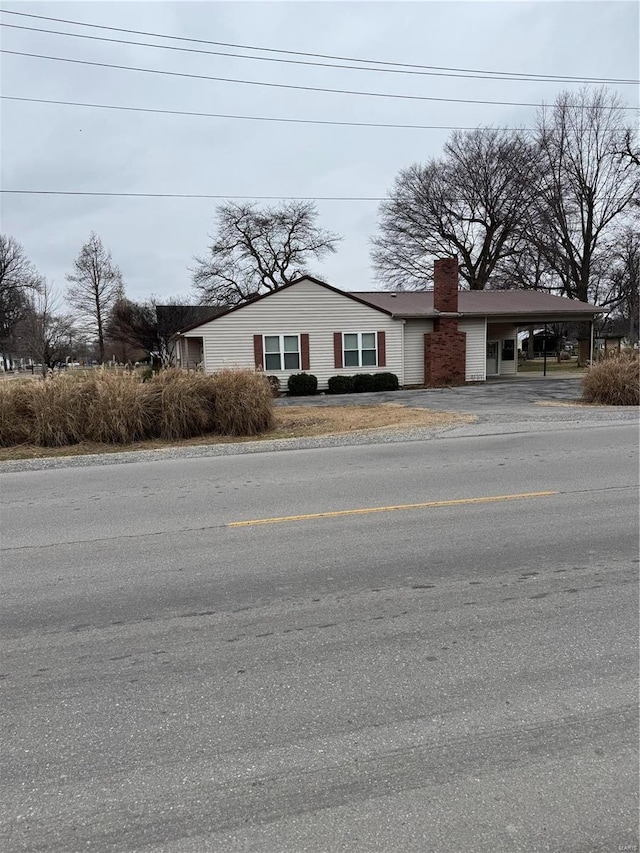 1028 Main St, New Madrid, MO 63869 - view of front of house featuring a carport, a chimney, and driveway