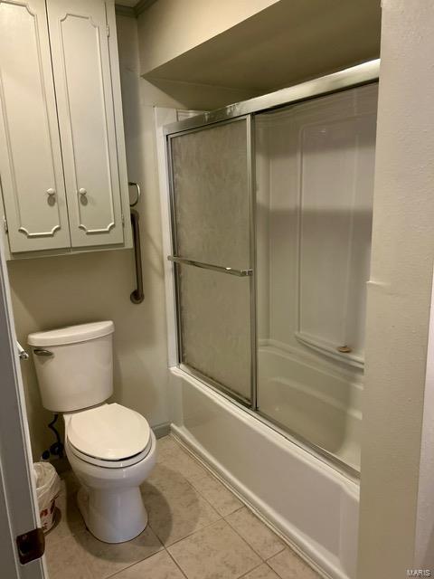 1028 Main St, New Madrid, MO 63869 - full bath with tile patterned flooring, shower / bath combination with glass door, and toilet
