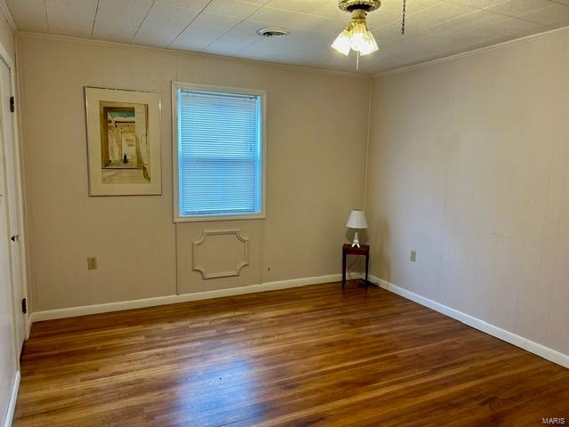 1028 Main St, New Madrid, MO 63869 - unfurnished room with crown molding, wood finished floors, and baseboards