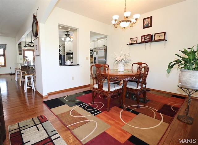 18921 Pleasant View Ln, Lebanon, MO 65536 - dining room with a chandelier, wood finished floors, baseboards, and ceiling fan