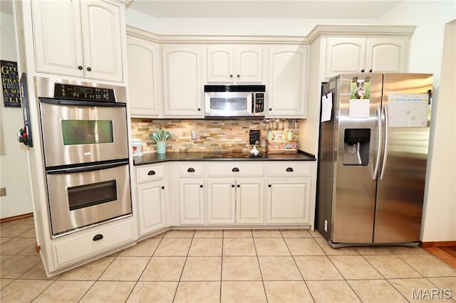 18921 Pleasant View Ln, Lebanon, MO 65536 - kitchen featuring stainless steel appliances, dark countertops, decorative backsplash, and light tile patterned flooring