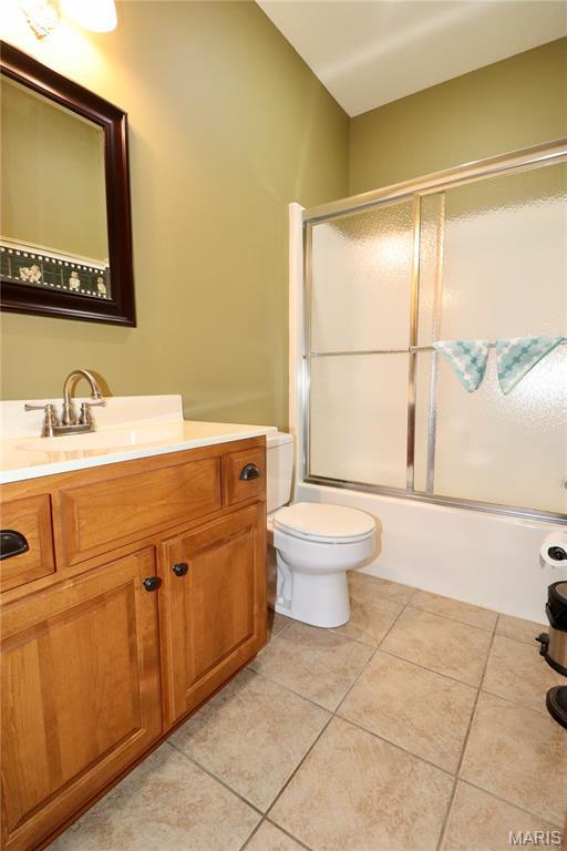 18921 Pleasant View Ln, Lebanon, MO 65536 - full bath with tile patterned flooring, toilet, bath / shower combo with glass door, and vanity